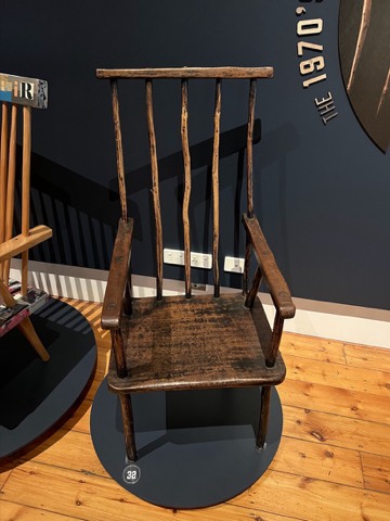 A tall-backed stick chair in dark timber — the Lovejoy Chair.