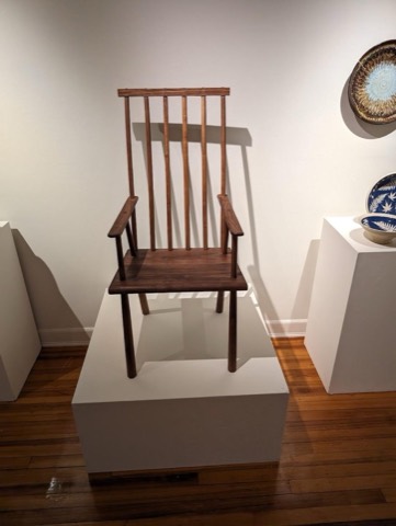 A dark walnut chair against a pale wall.