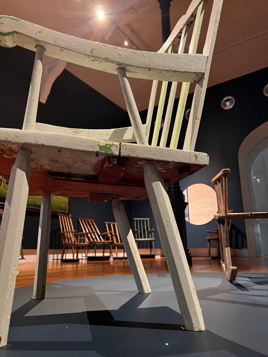 Looking up at the underside of an antique chair: the leg tenons pass through the slab seat.